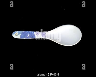 big plastic spoon isolated on black background Stock Photo