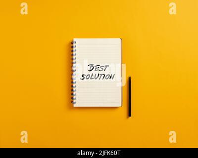 Notepad and black pen on yellow background with the word best solution. Business concept. Stock Photo