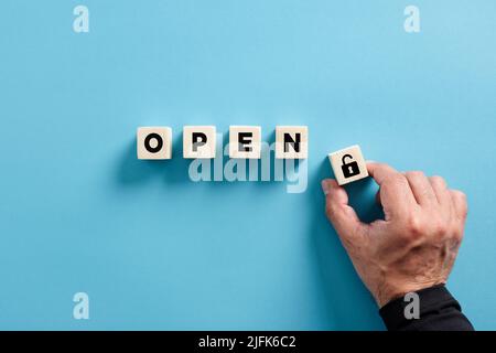 Male hand puts the wooden cube with padlock icon with the word open. Privacy, security, protection and safety concepts. Stock Photo