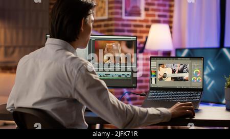 Asian videographer editing multimedia film footage on pc, using visual effects software on display. Developing video montage with color gradient, creating professional content. . Stock Photo