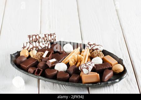 Assorted chocolate candies on black plate Stock Photo
