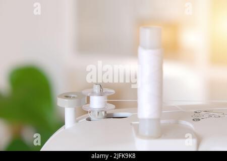 Winding threads on a bobbin on a sewing machine. Stock Photo