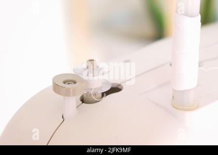 Winding threads on a bobbin on a sewing machine. Stock Photo