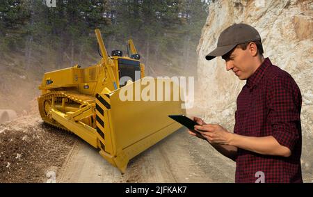 Engineer programs autonomous bulldozer using digital tablet Stock Photo