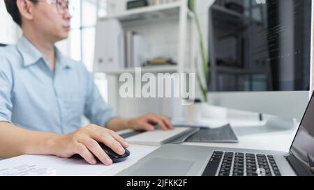 Software development concept, Male programmer typing data code on laptop to develop app and website. Stock Photo