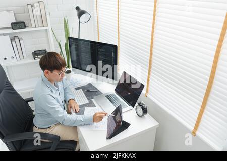 Software development concept, Male programmer point data on tablet to checking website programming. Stock Photo