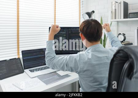 Software development concept, Male programmer excited and raise arms after successful programming. Stock Photo