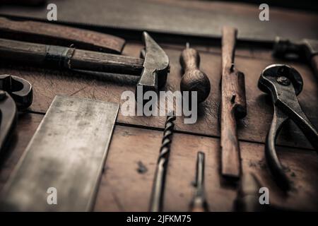close up picture of some carpentry tools on working table, hammer, square, drill, spokeshave, pincers and gouge for a craftsmanship concept Stock Photo