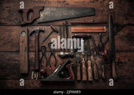 top view of carpenter’s rusty set tools on rustic background, pincers, drills, chisel, crowbar on workbench for a handwork concept Stock Photo
