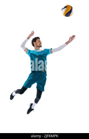 Portrait of young man, volleyball player in motion, training, hitting ball in a jump, playing isolated over white studio background Stock Photo
