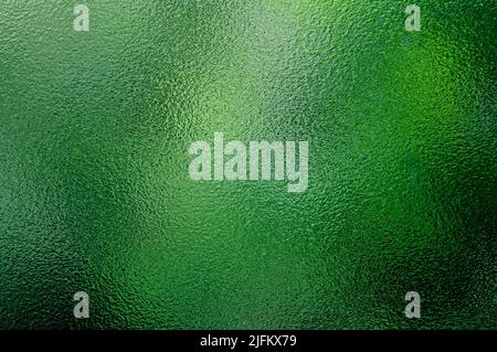 green foliage behind textured frosted glass window Stock Photo