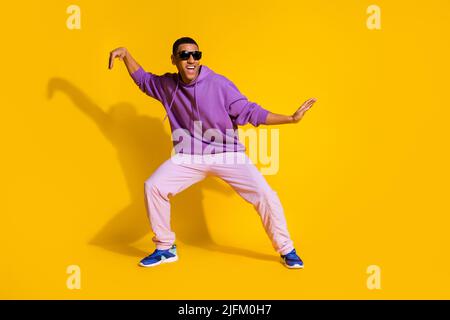 Full length body size view of attractive cheerful guy fooling dancing clubbing isolated over bright yellow color background Stock Photo