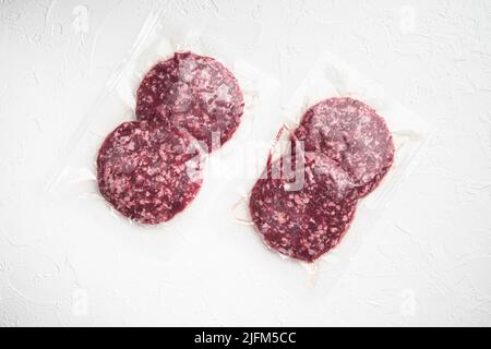 Beef patties in a vacuum packing, on white stone background, top view flat lay Stock Photo
