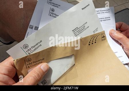 Close up of man person holding reading HMRC HM Revenue and Customs letter tax repayment payment England UK United Kingdom GB Great Britain Stock Photo