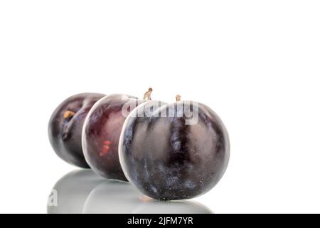 Three dark blue organic plums, close-up, isolated on white. dark blue organic plums, close-up, isolated on white. Stock Photo