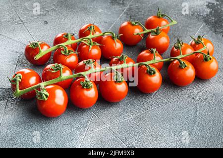 Cluster of fresh red cherry tomatoes, on gray stone background Stock Photo