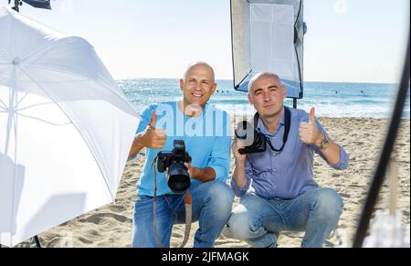 two photographers with their cameras during professional photo shooting Stock Photo