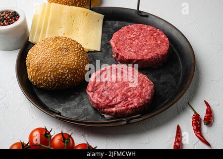 Raw fresh large beef burger on white stone table background Stock Photo