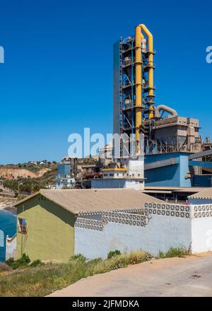 Cement factory in front of a village Stock Photo