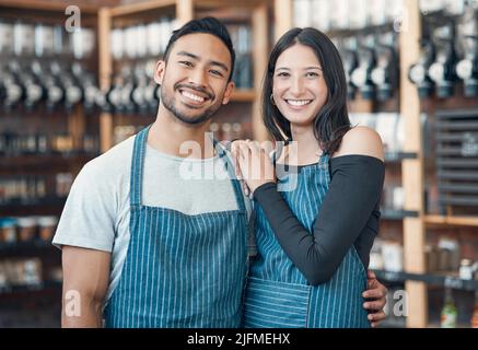 Portrait of a happy young hispanic man and woman working in a store or cafe. Friendly couple and coffeeshop owners managing a successful restaurant Stock Photo