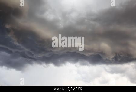 Dark storm clouds before rain, with strange cloud shapes. Storm clouds formed during the rainy season. Stock Photo