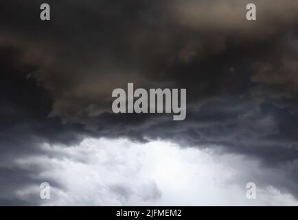 Dark storm clouds before rain, with strange cloud shapes. Storm clouds formed during the rainy season. Stock Photo