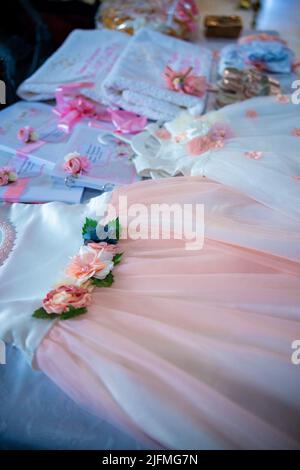 Baptism pictures. White gown baby with pink flowers outfit for religious celebration after birth. High quality photo Stock Photo