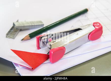 Stapler with staples wires on white paper in office Stock Photo