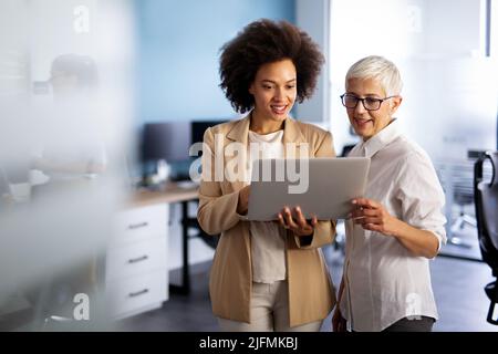 Happy smiling business women working together online on a laptop in office Stock Photo