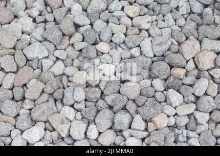 Gravel texture. Pebble stone background. Light grey closeup small rocks. Top view of ground gravel road. Stock Photo