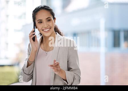 Business woman talking on her phone. Female entrepreneur making a call on her smartphone. Portrait of smiling businesswoman on a phone call Stock Photo