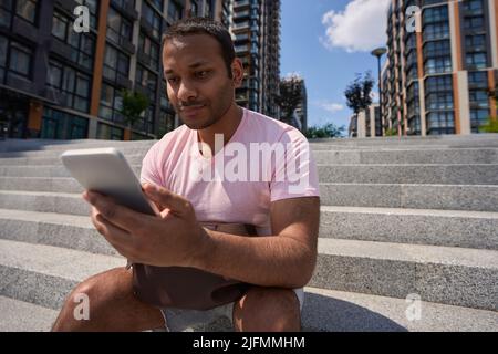 Concentrated man staring at cell phone in his hands Stock Photo