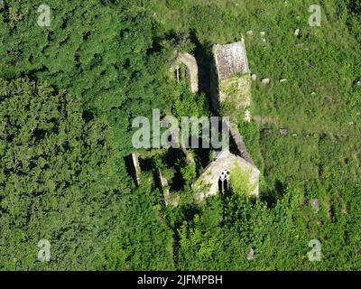 AERIAL VIEW. Abandoned church of St Mary and cemetery overgrown by vegetation. Tintern, Monmouthshire, Wales, United Kingdom. Stock Photo