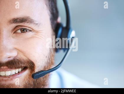 His patient and friendly attitude goes a long way. Portrait of a young call centre agent in an office. Stock Photo