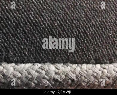 Close up of coarse grey textured fabric and edging in light and dark tones Stock Photo