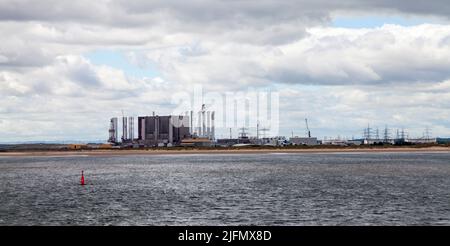 Hartlepool Nuclear Power Station , wind turbines and decommisioned oil rigs at Seaton Port as viewed from South Gare,Redcar,England,UK Stock Photo