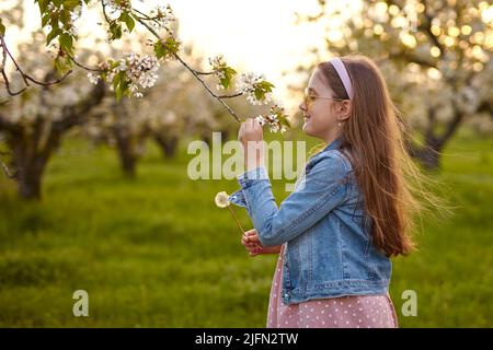 Little happy child girl in beautiful spring garden. Stock Photo