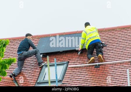 Installing solar panels on roof Stock Photo