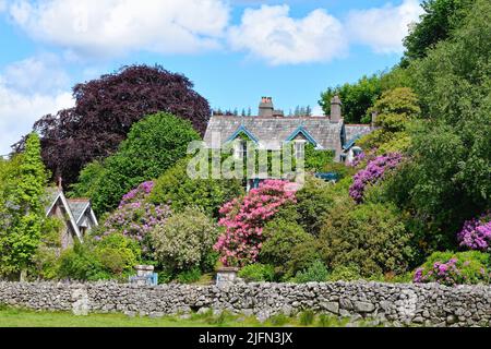 An attractive Victorian villa named Rock Wood cottage surround by colourful and lush foliage in Eskdale Green lake District Cumbria England UK Stock Photo
