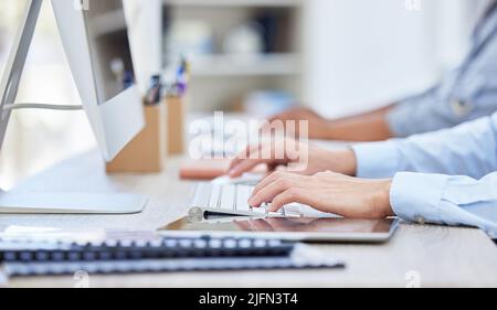 Close up of unknown business peoples hands typing on the keyboard in a office at work, A busy start up corporate work in a office Stock Photo