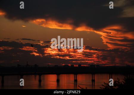 Sunset on the Dnieper River across the bridge in Ukraine in the city of Dnepr during the war, evening sunset in the city Stock Photo