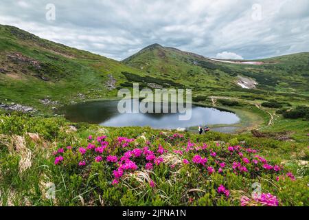 Lake Nesamovyte in the Ukrainian Carpathians. Mount Hoverla hanging peak of the Ukrainian Carpathians against the background of the sky and clouds Stock Photo
