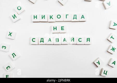 Never Give Up Motivation in russian scrabble Stock Photo