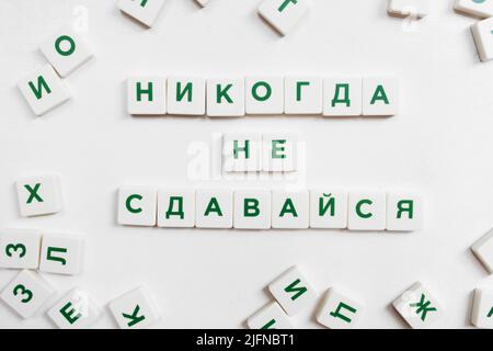 Never Give Up Motivation in russian scrabble Stock Photo