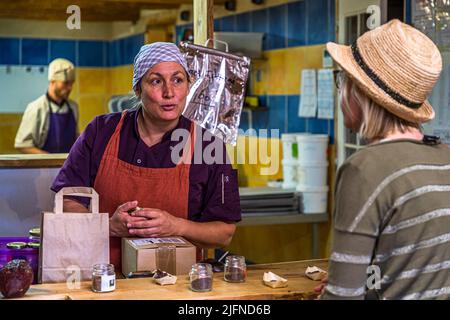 Shopping at Chocolaterie Frigoulettte in Beaufort-sur-Gervanne (Die, France). In the open kitchen in the background, nougat pralines are already being made for Christmas in summer. Die, France Stock Photo