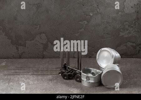 Set of new car pistons and valves on concrete gray background, car repair parts, copy space Stock Photo