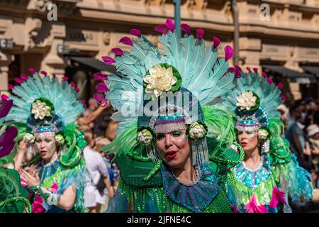 Female dancers wearing green and turquoise feather costumes at Helsinki Samba Carnaval parade in Pohjoisesplanadi, Helsinki, Finland Stock Photo