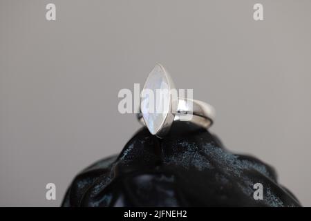 A silver moonstone ring on a black surface Stock Photo