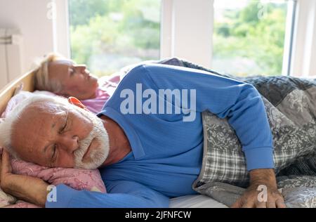 Senior coupke sleeping in bed on morning sun Stock Photo