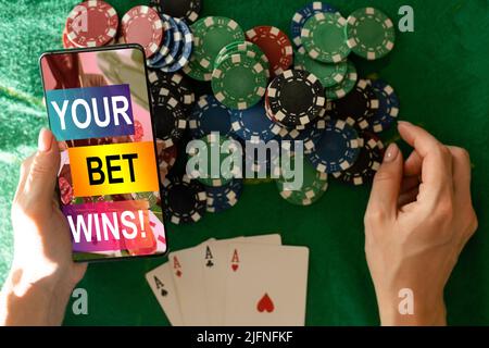 inscription your bet wins on a smartphone on the poker table. Stock Photo